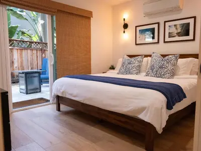 a bedroom with a large bed and a balcony at Luxury 2BR Steps to Beach & Pier with AC plus Garage Parking in Newport Beach
