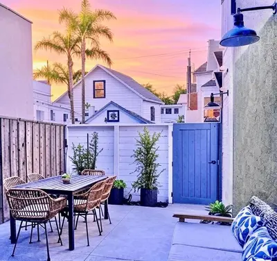 a patio with a table and chairs and a fence at Luxury 2BR Steps to Beach & Pier with AC plus Garage Parking in Newport Beach