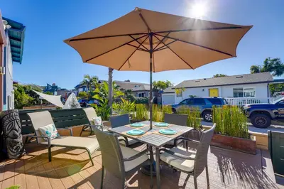 a table with an umbrella on a patio at Stunning Beach Home - large patio, parking, ac & dog friendly! in San Diego