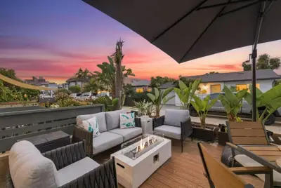 an outdoor patio with furniture and an umbrella at Stunning Beach Home - large patio, parking, ac & dog friendly! in San Diego
