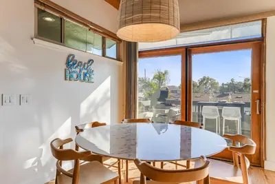 a dining room with a table and chairs and a window at Stunning South Mission Beach Home - AC, Private Patio, Grill and Garage! in San Diego