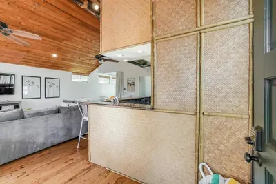 an open kitchen and living room with a wooden ceiling at Stunning South Mission Beach Home - AC, Private Patio, Grill and Garage! in San Diego