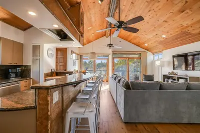 a kitchen and living room with a bar and a ceiling fan at Stunning South Mission Beach Home - AC, Private Patio, Grill and Garage! in San Diego