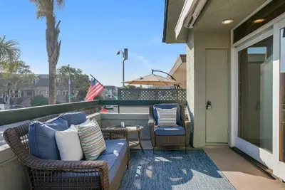 a patio with two chairs and a couch on a balcony at Stunning South Mission Beach Home - AC, Private Patio, Grill and Garage! in San Diego
