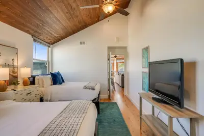 a bedroom with two beds and a flat screen tv at Stunning South Mission Beach Home - AC, Private Patio, Grill and Garage! in San Diego