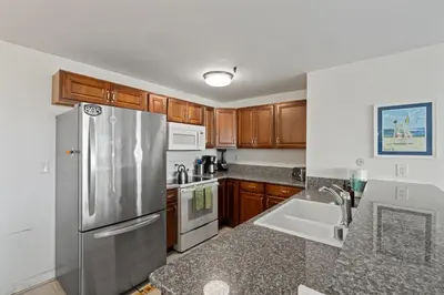 a kitchen with a stainless steel refrigerator and a sink at Belmont Ocean Views - Massive Private Deck, Grill & Parking in San Diego