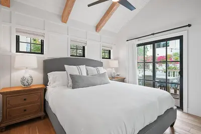 a white bedroom with a bed and a ceiling fan at Neptune Experience in Encinitas