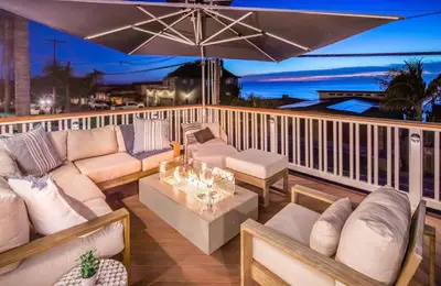 a balcony with couches and an umbrella at Neptune Experience in Encinitas