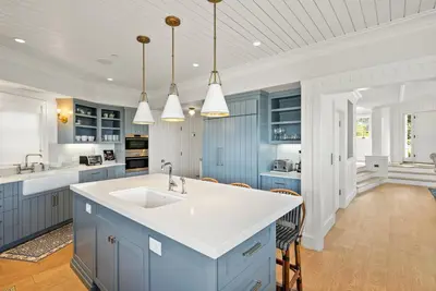 a kitchen with blue cabinets and a white sink at Coastal La Jolla Luxury w AC, Patios, & Massive Ocean Views! in San Diego