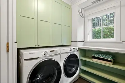 a laundry room with a washing machine and green cabinets at Coastal La Jolla Luxury w AC, Patios, & Massive Ocean Views! in San Diego