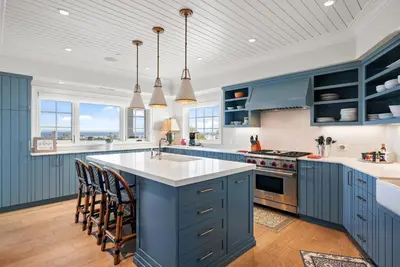 a kitchen with blue cabinets and a large island at Coastal La Jolla Luxury w AC, Patios, & Massive Ocean Views! in San Diego