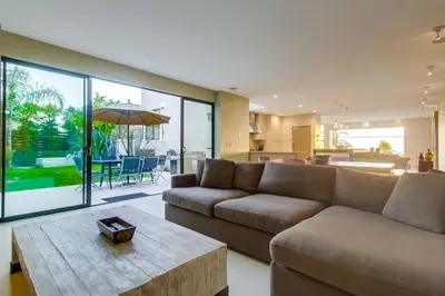 a living room with a couch and a table at Sunset Cliffs Modern Luxury Estate w Ocean Views, Oversized Spa, AC, Yard! in San Diego