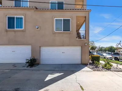 a house with two garage doors in front of it at Pacific Beach Paradise - Near the Beach w AC, Garage, Fast Wifi & Private Patio! in San Diego
