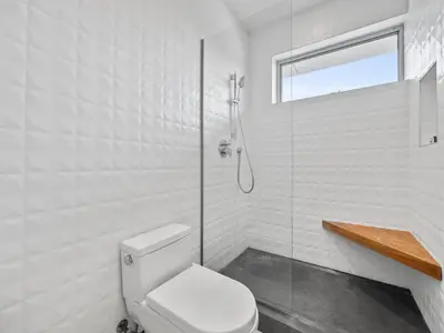 a white bathroom with a toilet and a shower at Luxury Coastal Home - Pool, Spa, AC, & Ocean Views in Solana Beach