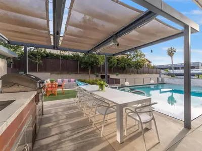 a patio with a table and chairs and a swimming pool at Luxury Coastal Home - Pool, Spa, AC, & Ocean Views in Solana Beach