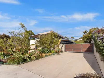 a house with a wooden gate in front of a driveway at Luxury Coastal Home - Pool, Spa, AC, & Ocean Views in Solana Beach