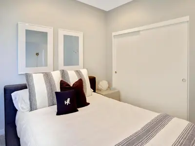 a bedroom with a large white bed with pillows at Haines Luxury Dream Home - Bay Views, Rooftop, Fire Pit & AC in San Diego