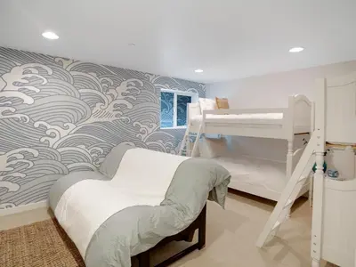 a bedroom with two bunk beds and a wave mural at Haines Luxury Dream Home - Bay Views, Rooftop, Fire Pit & AC in San Diego