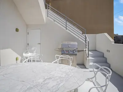 a dining room with a table and chairs and stairs at Haines Luxury Dream Home - Bay Views, Rooftop, Fire Pit & AC in San Diego