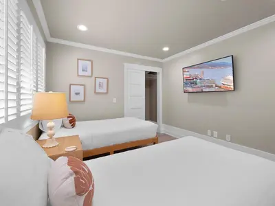 a bedroom with two beds and a tv on the wall at Kennebeck Oasis - Private Patio, Steps 2 Sand & AC in San Diego