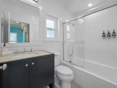 a white bathroom with a toilet and a sink at Kennebeck Oasis - Private Patio, Steps 2 Sand & AC in San Diego