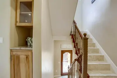 a staircase in a home with white walls and wooden stairs at Stunning Ocean View Home w Rooftop Terrace, Firepit, Fast Wifi, AC & Parking! in San Diego