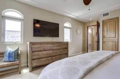 a bedroom with a large bed and a flat screen tv at Stunning Ocean View Home w Rooftop Terrace, Firepit, Fast Wifi, AC & Parking! in San Diego