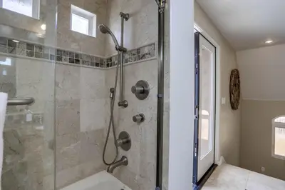a bathroom with a shower with a glass door at Stunning Ocean View Home w Rooftop Terrace, Firepit, Fast Wifi, AC & Parking! in San Diego
