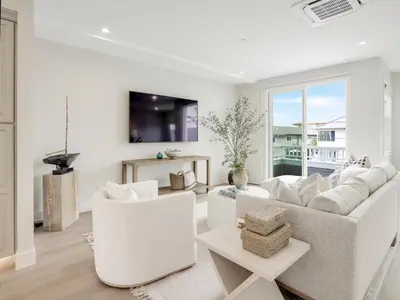 a living room with white furniture and a large window at Coastal retreat near the beach w Panoramic Ocean Views, Rooftop Deck, & Firepit in San Diego