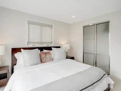 a white bedroom with a large bed and a window at Coastal retreat near the beach w Panoramic Ocean Views, Rooftop Deck, & Firepit in San Diego