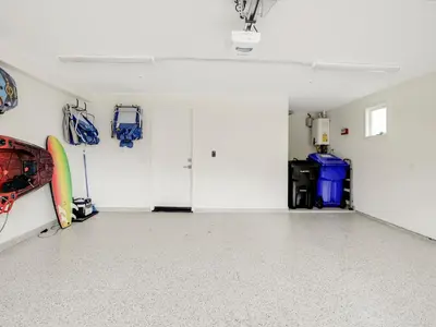 a room with white walls and surfboards on the wall at Coastal retreat near the beach w Panoramic Ocean Views, Rooftop Deck, & Firepit in San Diego