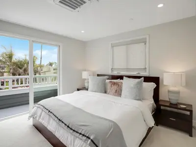 a white bedroom with a large bed and a window at Coastal retreat near the beach w Panoramic Ocean Views, Rooftop Deck, & Firepit in San Diego