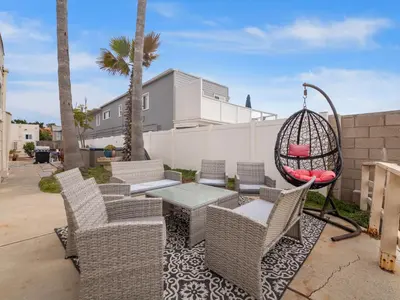 a patio with chairs and a table and a swing at Oceanfront Paradise - Spa, Pet-Friendly, Fast Wifi, Parking & Dream Views in San Diego