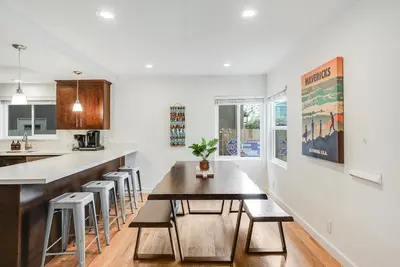 a kitchen with a table and chairs and a counter at Massive Beach Home w Stunning Rooftop, Parking, Spa, AC & Bay Views! in San Diego