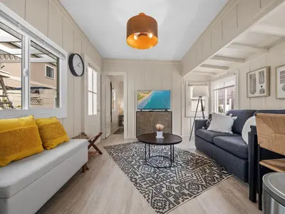 a living room with a couch and a table at Sunset Cliffs Oceanfront Casita w Fast Wifi, Large Outdoor Space & Ocean Breeze! in San Diego