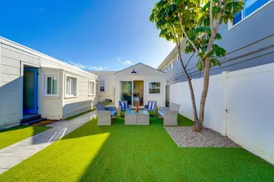 a backyard with a palm tree and a house at Sunset Cliffs Oceanfront Casita w Fast Wifi, Large Outdoor Space & Ocean Breeze! in San Diego