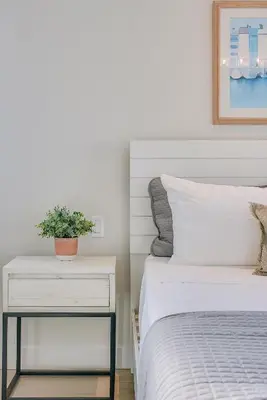 a bedroom with a bed and a nightstand with a plant on it at Beautiful Beach Home - Ocean View, AC & Patio in San Diego