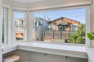 a window with a view of a building at Beautiful Beach Home - Ocean View, AC & Patio in San Diego