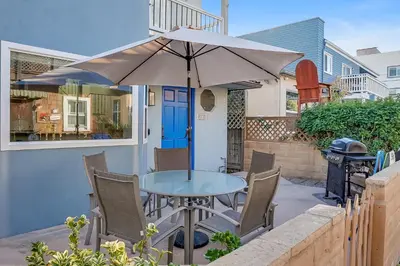 a table and chairs with an umbrella on a patio at Beautiful Beach Home - Ocean View, AC & Patio in San Diego