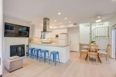 a kitchen with blue stools and a bar with a table at Beautiful Beach Home - Ocean View, AC & Patio in San Diego