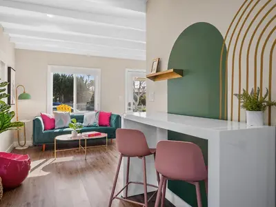 a living room with a kitchen with pink and green at Classic Beach Bungalow - Parking, Private Patio & Pet Friendly! in San Diego