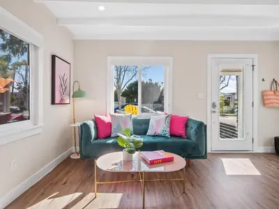 a living room with a green couch and a table at Classic Beach Bungalow - Parking, Private Patio & Pet Friendly! in San Diego