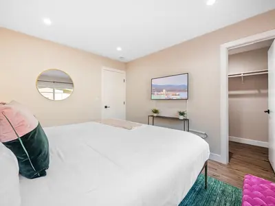 a bedroom with a large white bed and a window at Classic Beach Bungalow - Parking, Private Patio & Pet Friendly! in San Diego