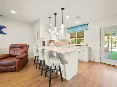 a kitchen with a bar with stools at Bay Park Garden Paradise - central Location, AC, Washer Dryer & Private yard! in San Diego