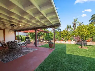 a patio with a table and chairs on a lawn at Bay Park Garden Paradise - central Location, AC, Washer Dryer & Private yard! in San Diego