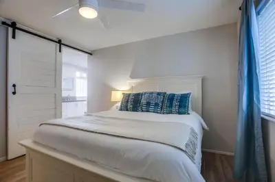 a bedroom with a white bed with blue pillows at Ormond Beach Oasis - Large Private Patio, WasherDryer, Pet Friendly & Steps2Sand! in San Diego
