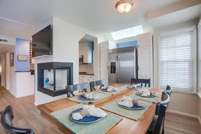 a dining room with a table and chairs and a fireplace at Ormond Beach Oasis - Large Private Patio, WasherDryer, Pet Friendly & Steps2Sand! in San Diego