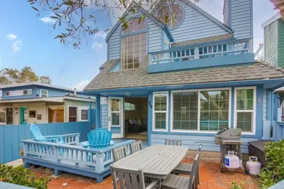 a blue house with a table and chairs on a patio at Ormond Beach Oasis - Large Private Patio, WasherDryer, Pet Friendly & Steps2Sand! in San Diego