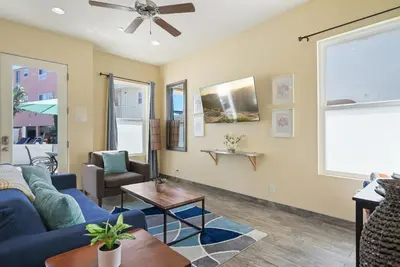 a living room with a blue couch and a table at Mission Paradise - Spa, Pet Friendly, Steps2Sand in San Diego