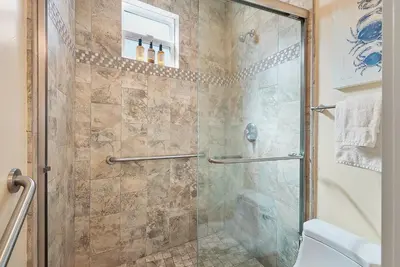 a bathroom with a glass shower with a toilet at Mission Paradise - Spa, Pet Friendly, Steps2Sand in San Diego